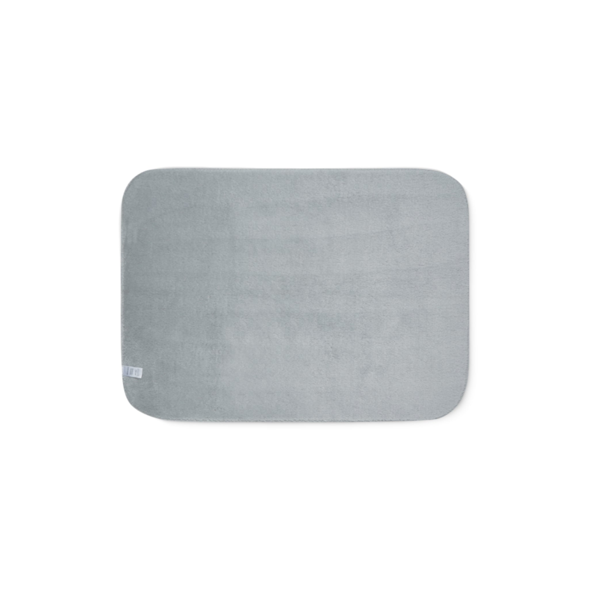 Grey sherpa side of two-coloured blanket.