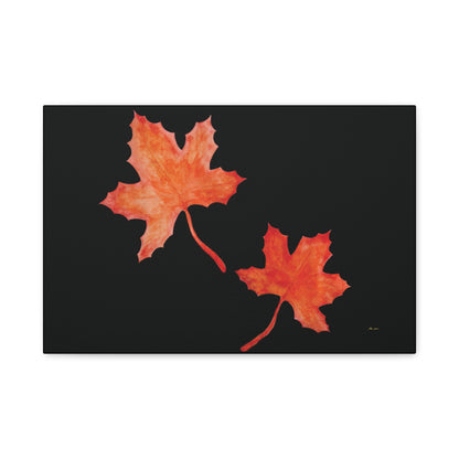 Black stretched canvas adorned with two orange-red watercolour maple leaves and eKuumeArt logo – front view.