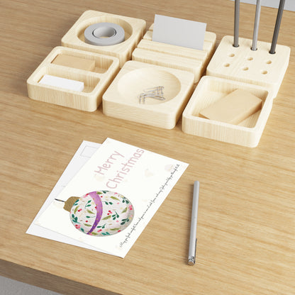 Christmas postcard with watercolour Christmas ball and prayer text  – displayed on wooden desk with wooden organizer with compartments and pen.