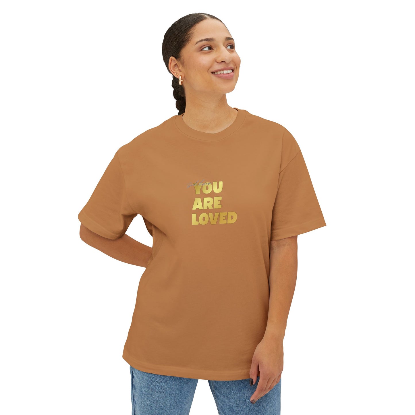 Woman wearing toast oversized boxy t-shirt adorned with 'You Are Loved' text in gold on chest.