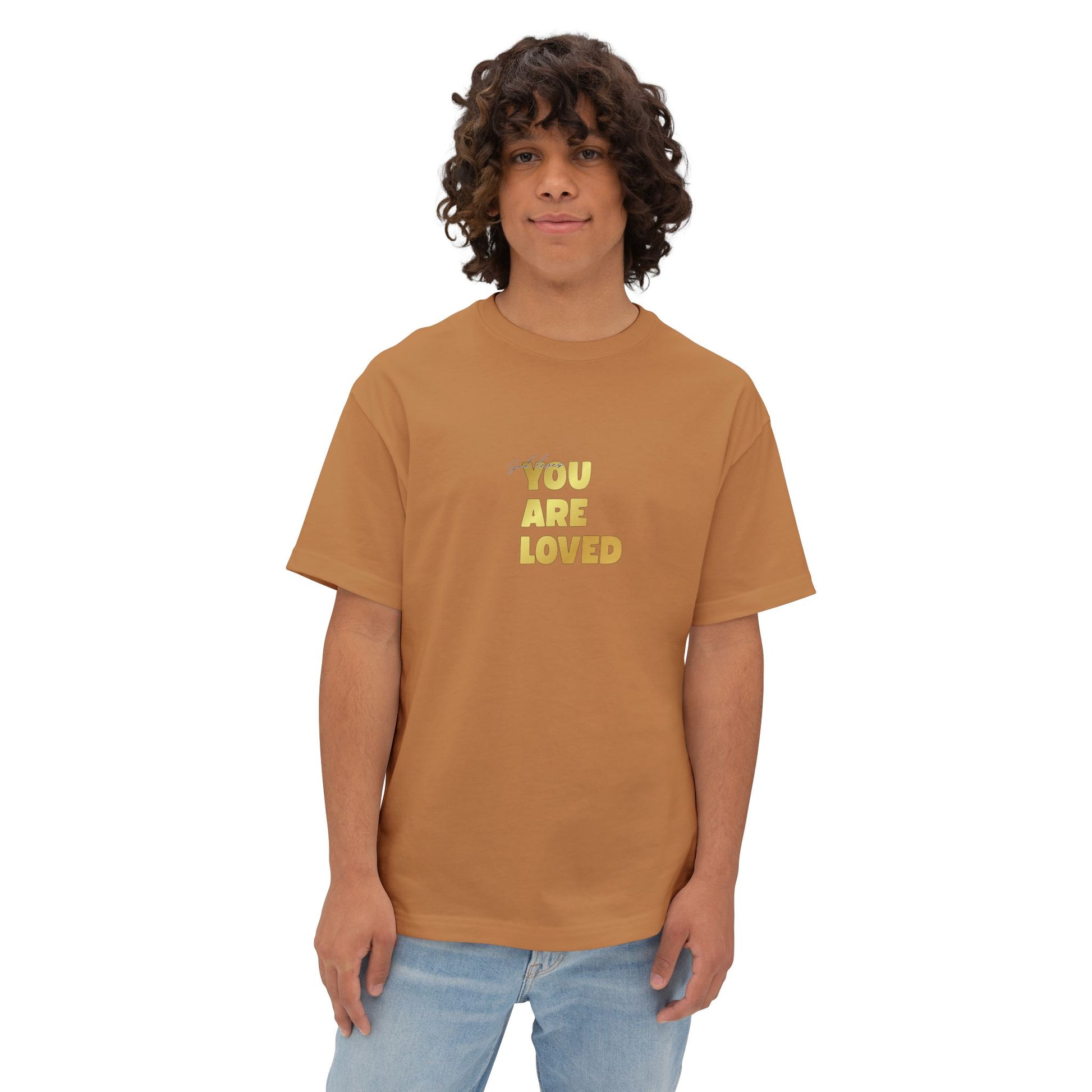 Man wearing toast oversized boxy t-shirt adorned with 'You Are Loved' text in gold on chest.