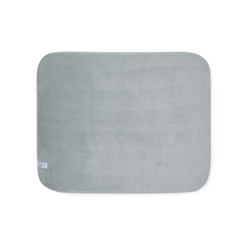 Grey sherpa side of two-coloured blanket.