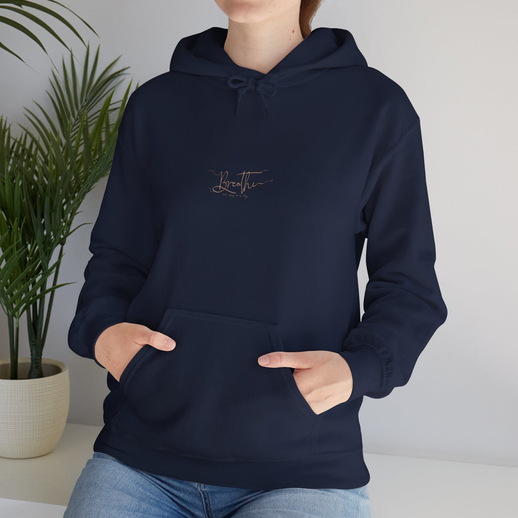 Woman wearing navy hoodie with 'Breathe' handwritten text on chest, closeup – featuring a palm plant in the background.
