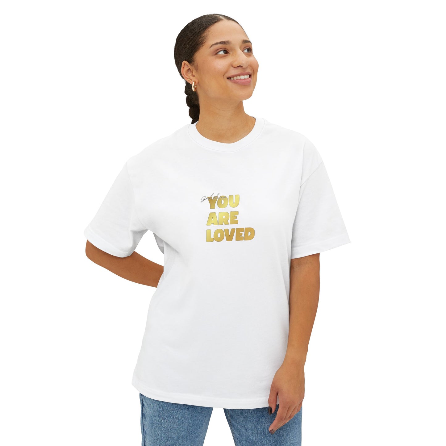 Woman wearing white oversized boxy t-shirt adorned with 'You Are Loved' text in gold on chest.