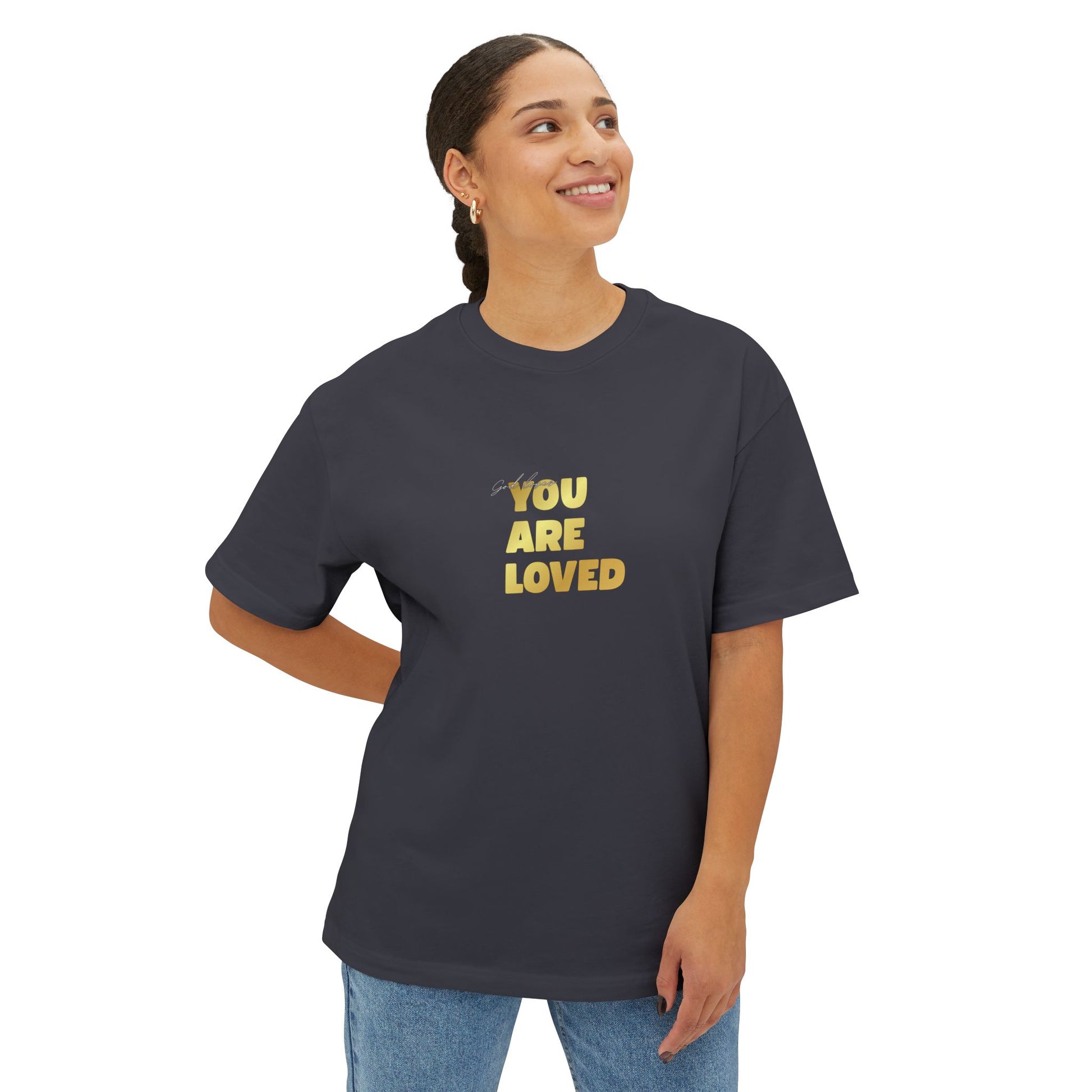 Woman wearing dark grey oversized boxy t-shirt adorned with 'You Are Loved' text in gold on chest.