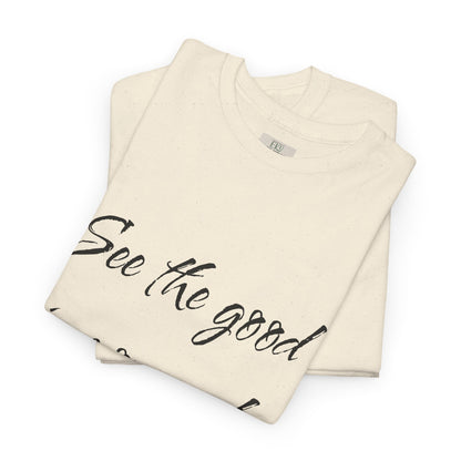 Folded natural/beige heavy cotton t-shirt with ‘See the good…’ motivational quote text and eKuumeArt’s neck label.