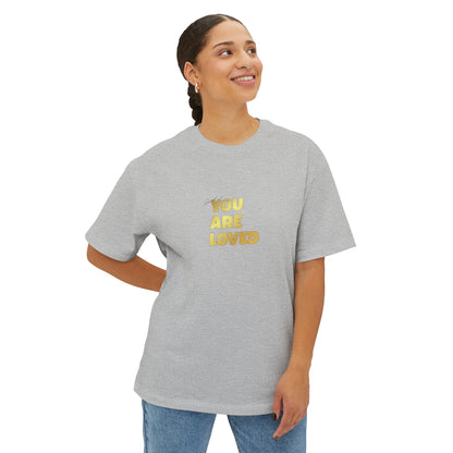 Woman wearing athletic heather oversized boxy t-shirt adorned with 'You Are Loved' text in gold on chest.