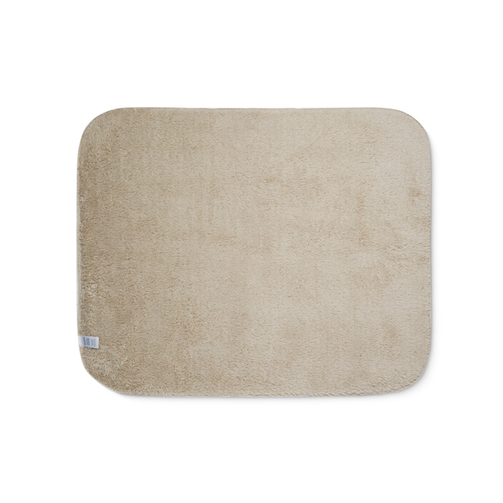 Beige sherpa side of two-coloured blanket.