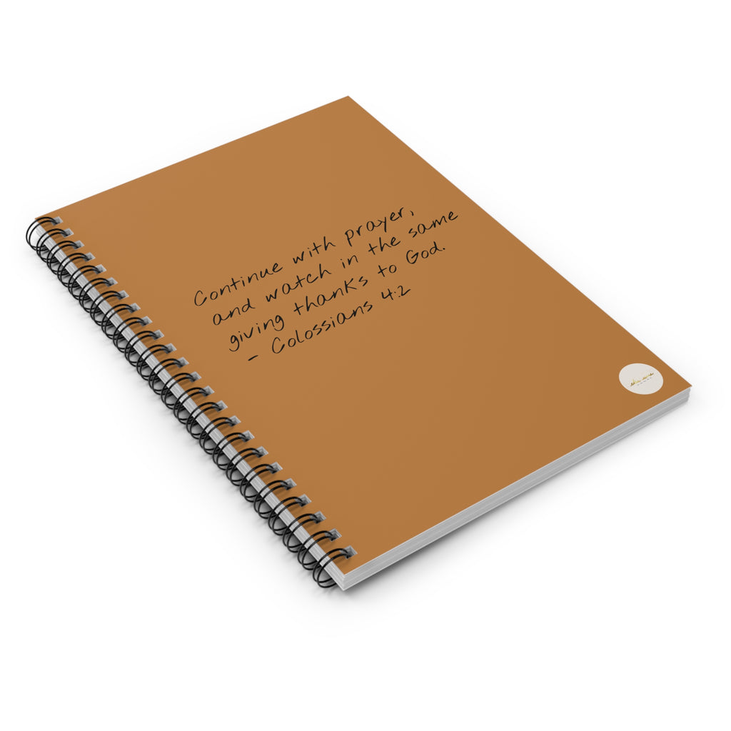 Spiral journal/notebook with 'Colossians 4:2' scripture text and eKuumeArt logo on the front cover - angled view