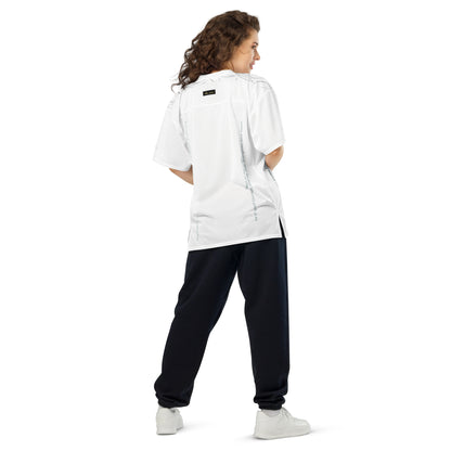 Woman wearing white mesh football jersey adorned with lined leaves across shoulder area, eKuumeArt logo and scripture text – back view, showing side slits.