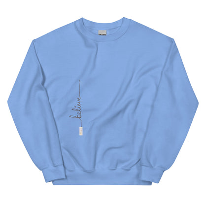 Carolina Blue sweater adorned with 'Believe' handwritten text and eKuumeArt logo on torso.
