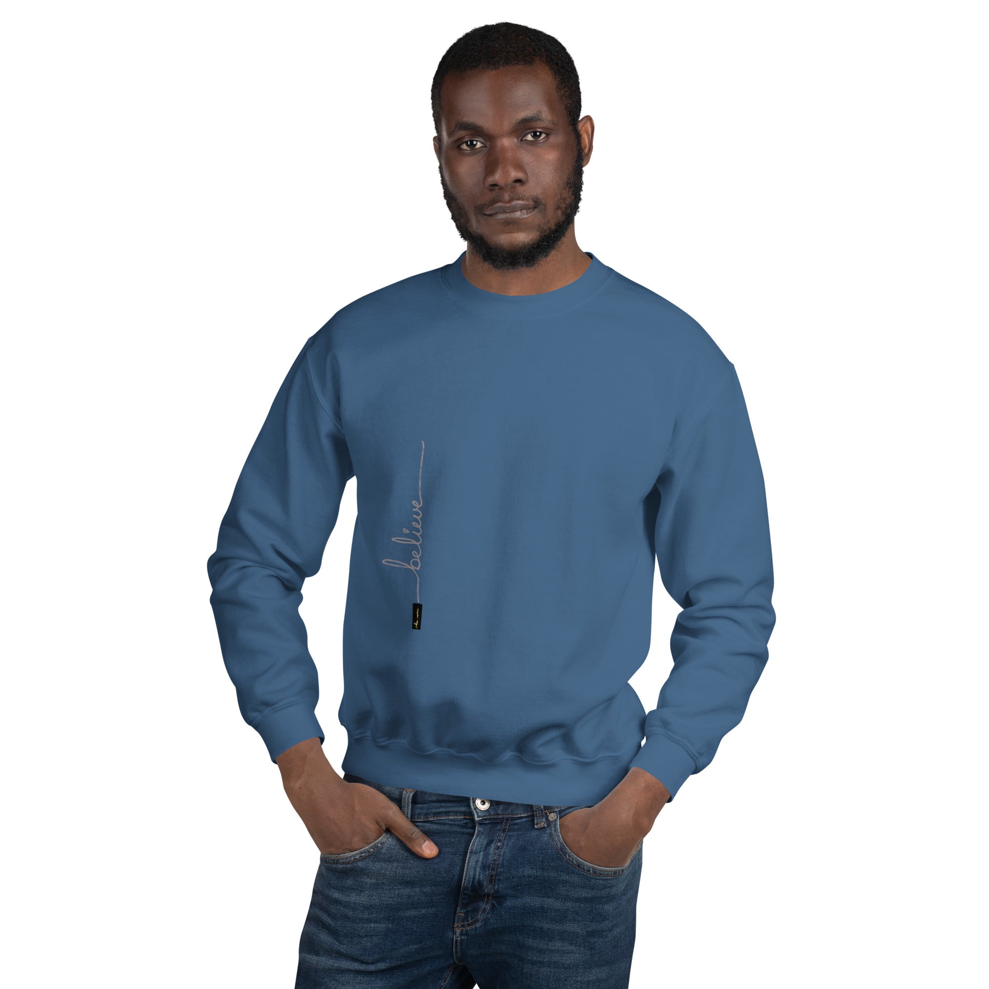 Man wearing indigo blue sweater with 'Believe' handwritten text and eKuumeArt logo on torso – front view.
