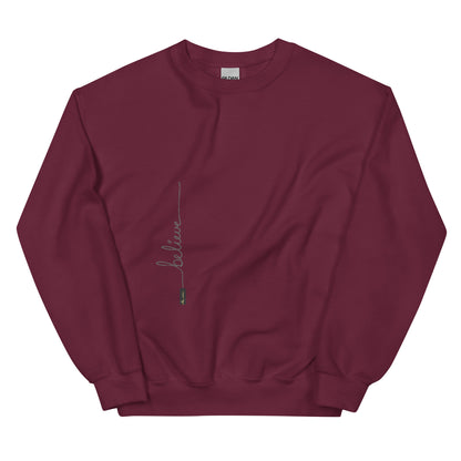 Maroon sweater adorned with 'Believe' handwritten text and eKuumeArt logo on torso.