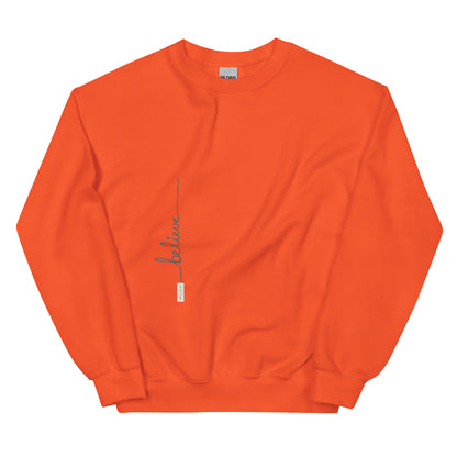 Orange sweater adorned with 'Believe' handwritten text and eKuumeArt logo on torso.