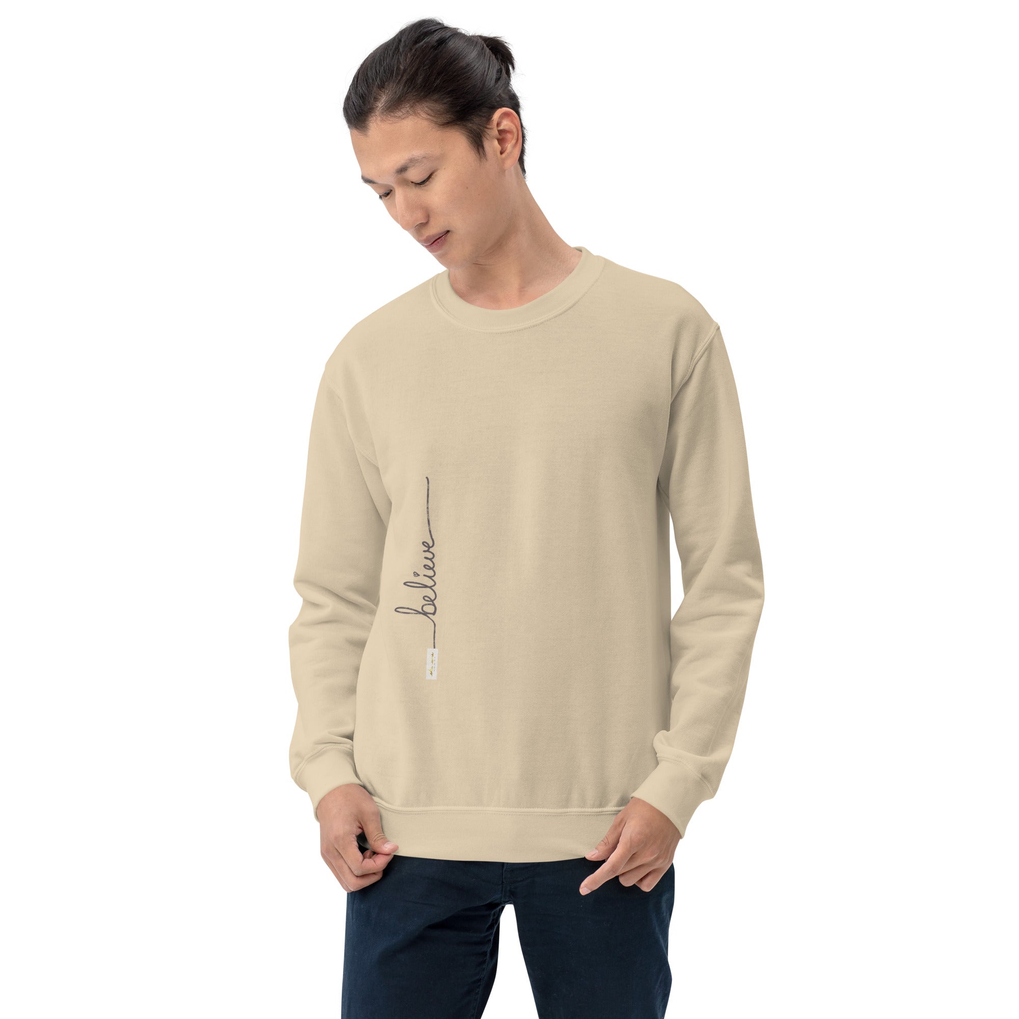 Man wearing sand sweater with 'Believe' handwritten text and eKuumeArt logo on torso – front view.