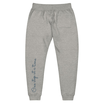 Carbon grey sweatpants adorned with 'One step at a time' text on back left leg.