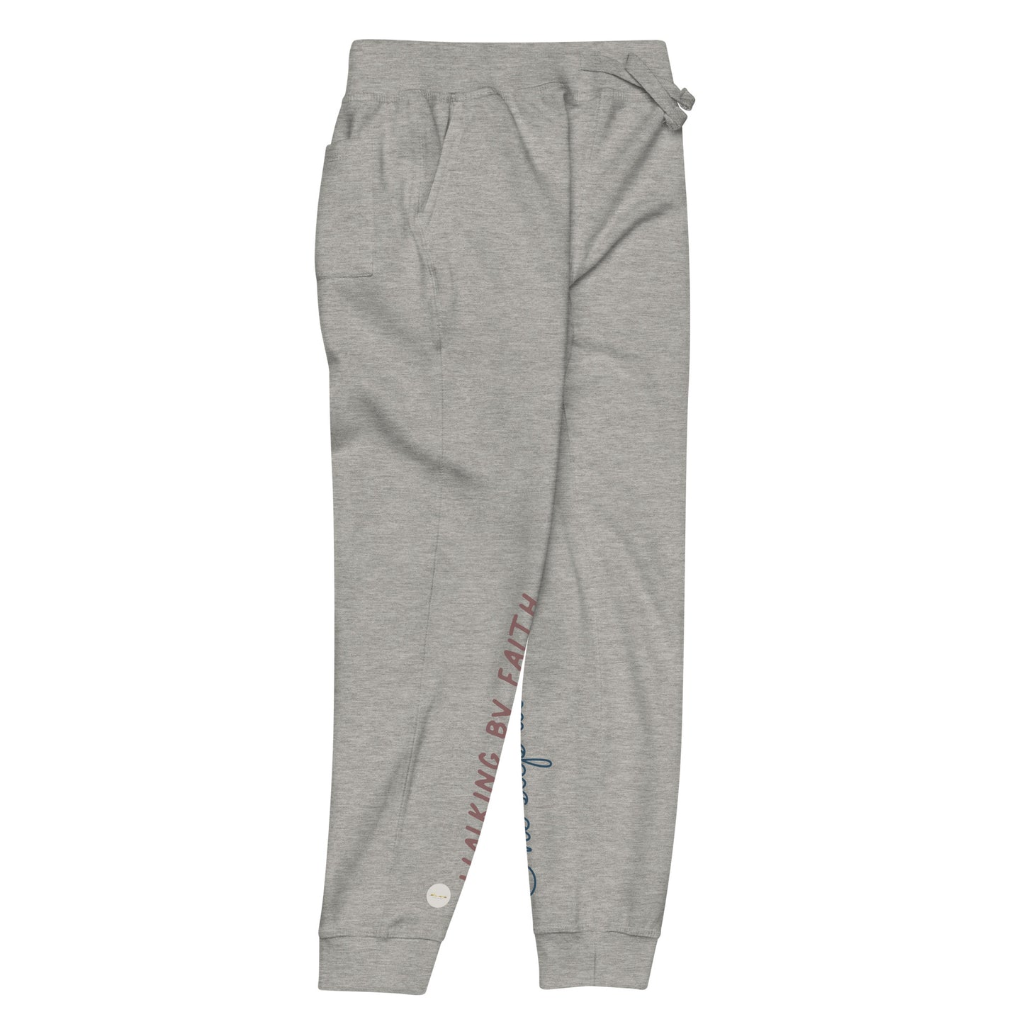Carbon grey sweatpants adorned with 'Walking by faith' text and eKuumeArt logo on front right leg and glimpse of 'One step at a time' on back left leg – side view.
