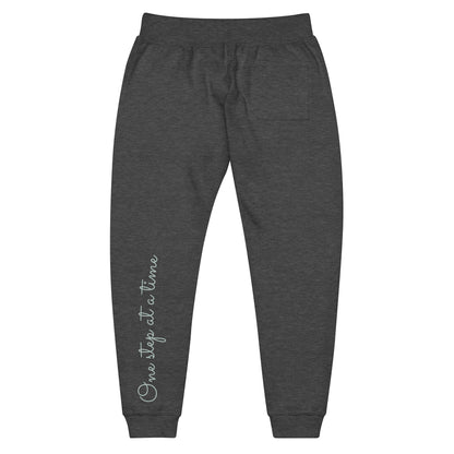 Charcoal Heather sweatpants adorned with 'One step at a time' text on back left leg.