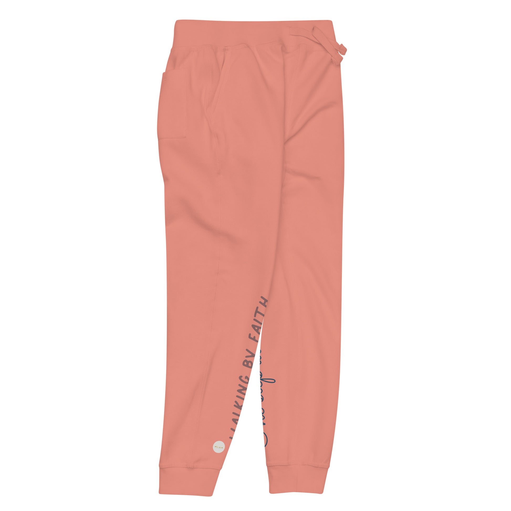 Dusty rose sweatpants adorned with 'Walking by faith' text and eKuumeArt logo on front right leg with glimpse of 'One step at a time' on back left leg – side view.