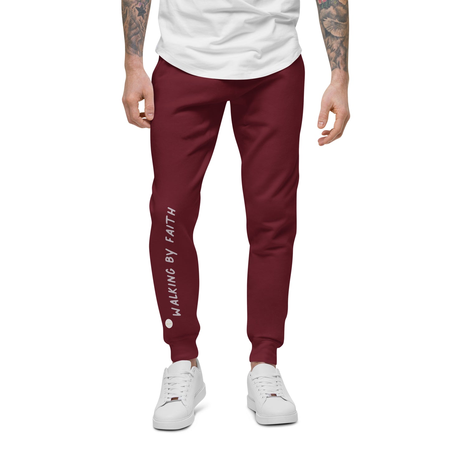 Person wearing maroon sweatpants with 'Walking by faith' text and eKuumeArt logo on front right leg – front view.