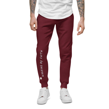 Person wearing maroon sweatpants with 'Walking by faith' text and eKuumeArt logo on front right leg – front view.