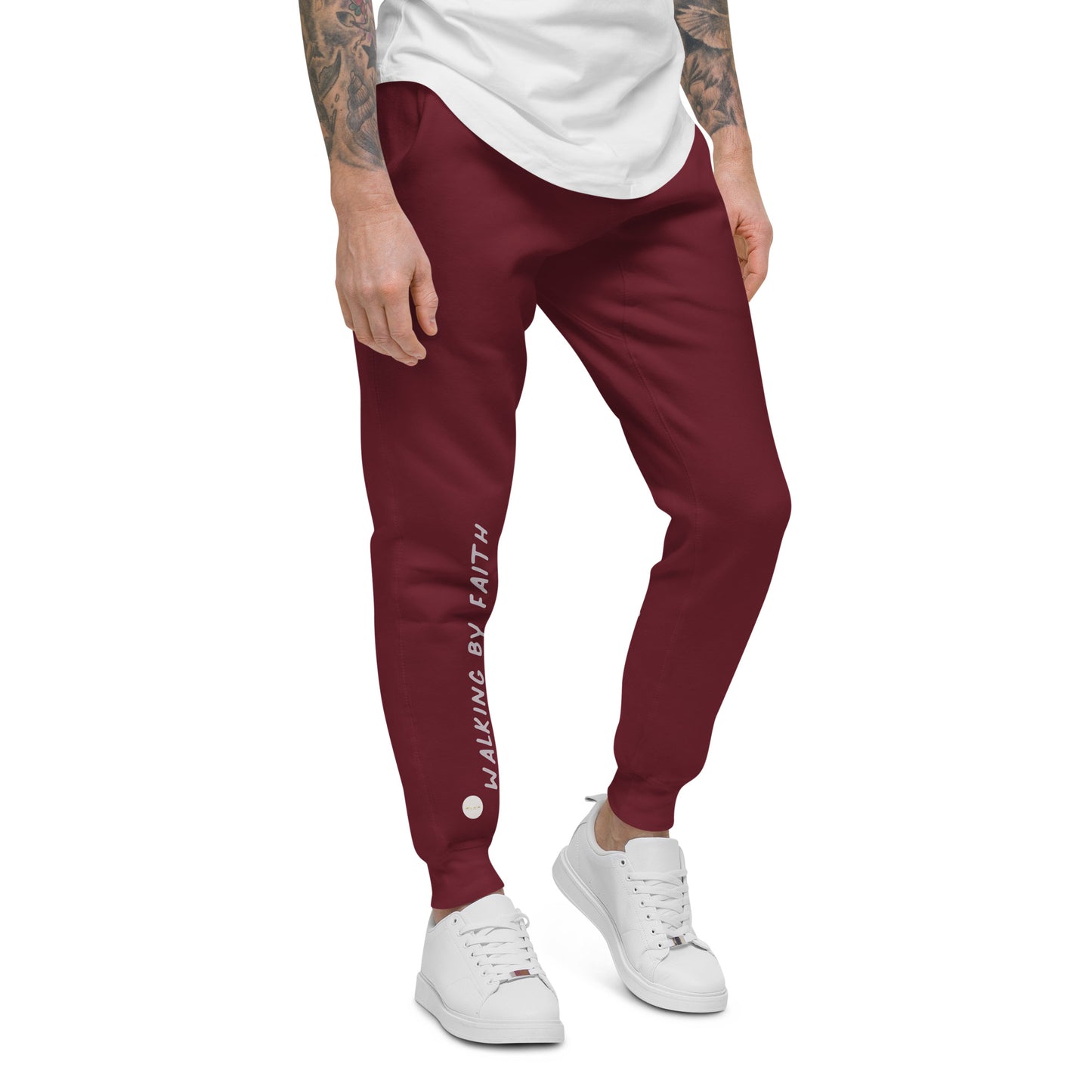 Person wearing maroon sweatpants with 'Walking by faith' text and eKuumeArt logo on front right leg – angled view.