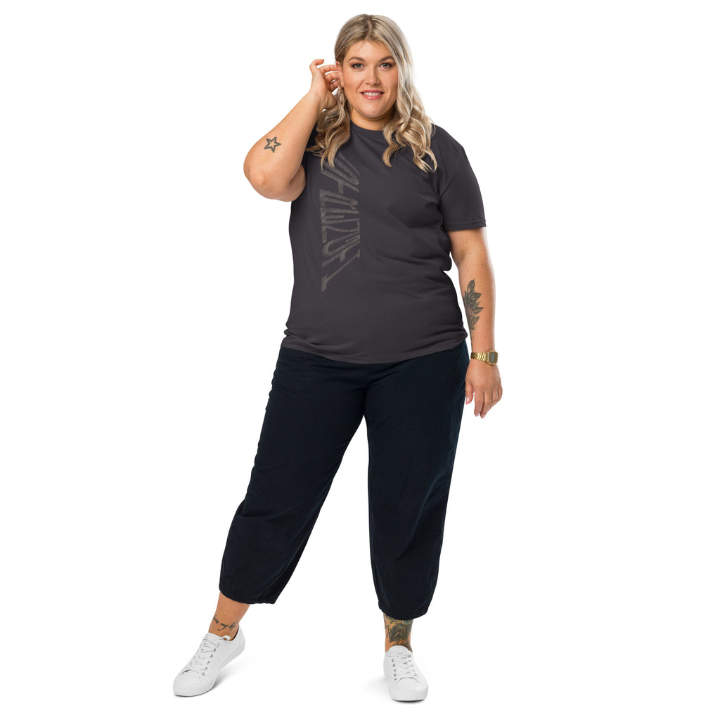 Woman wearing anthracite grey organic cotton t-shirt with hand-drawn 'Strength' text, black trousers and white sneakers | eKuumeArt.