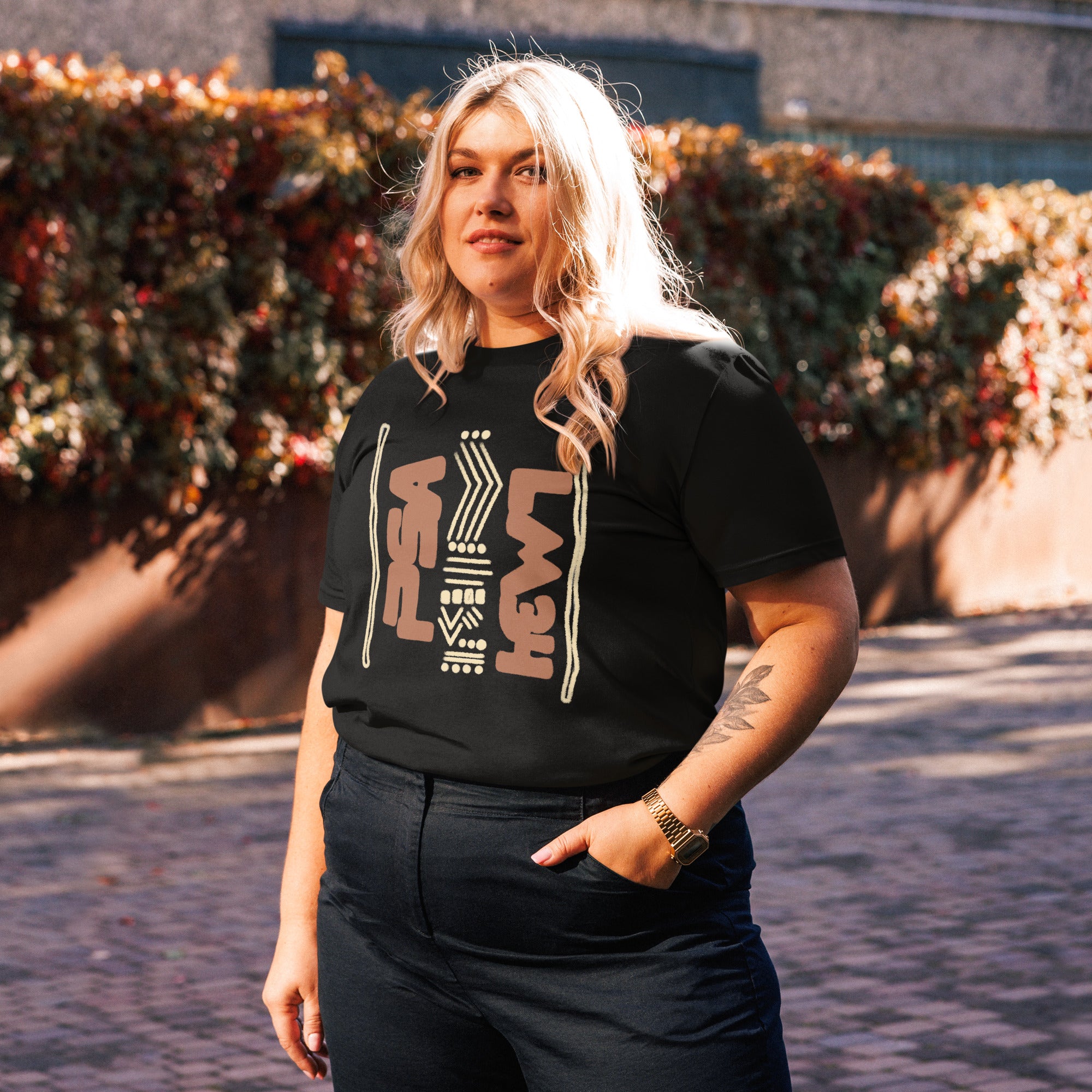 Woman wearing a black organic cotton t-shirt with hand-drawn design, in a peaceful outdoor setting | eKuumeArt.