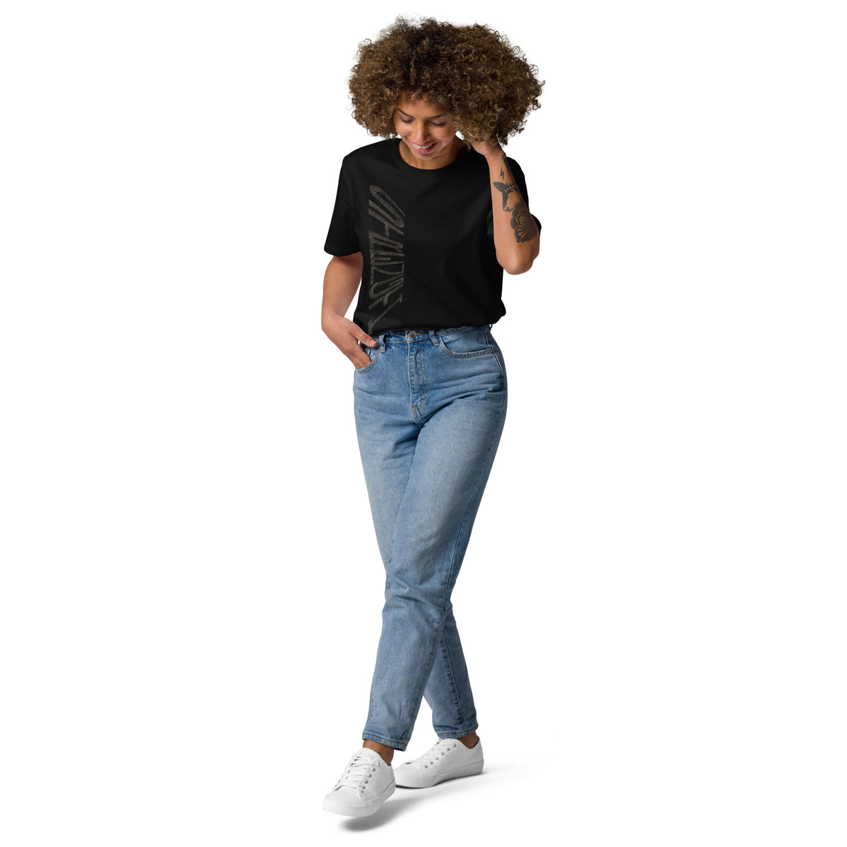 Lady wearing black organic cotton t-shirt with hand-drawn 'Strength' text and blue jeans | eKuumeArt.