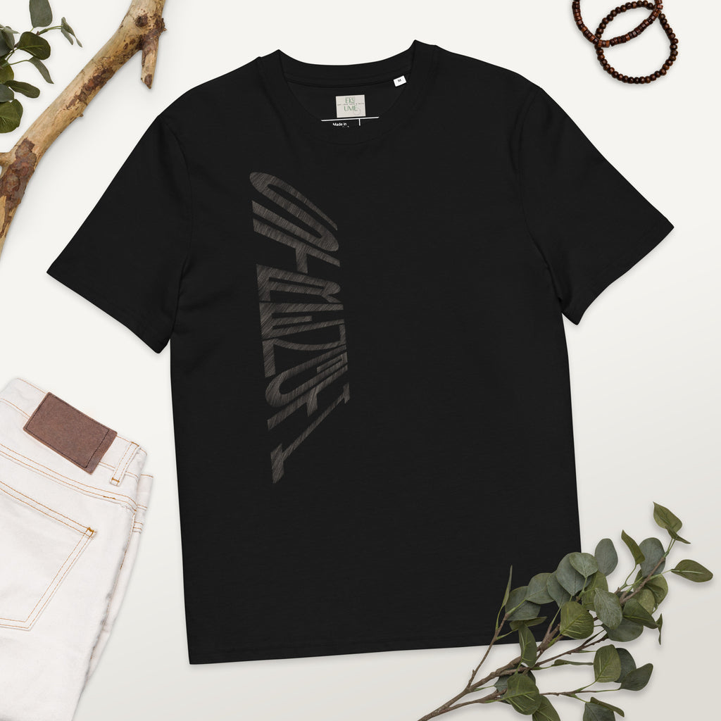 Black organic cotton t-shirt with hand-drawn 'Strength' text and white jeans on a white surface with greenery | eKuumeArt.