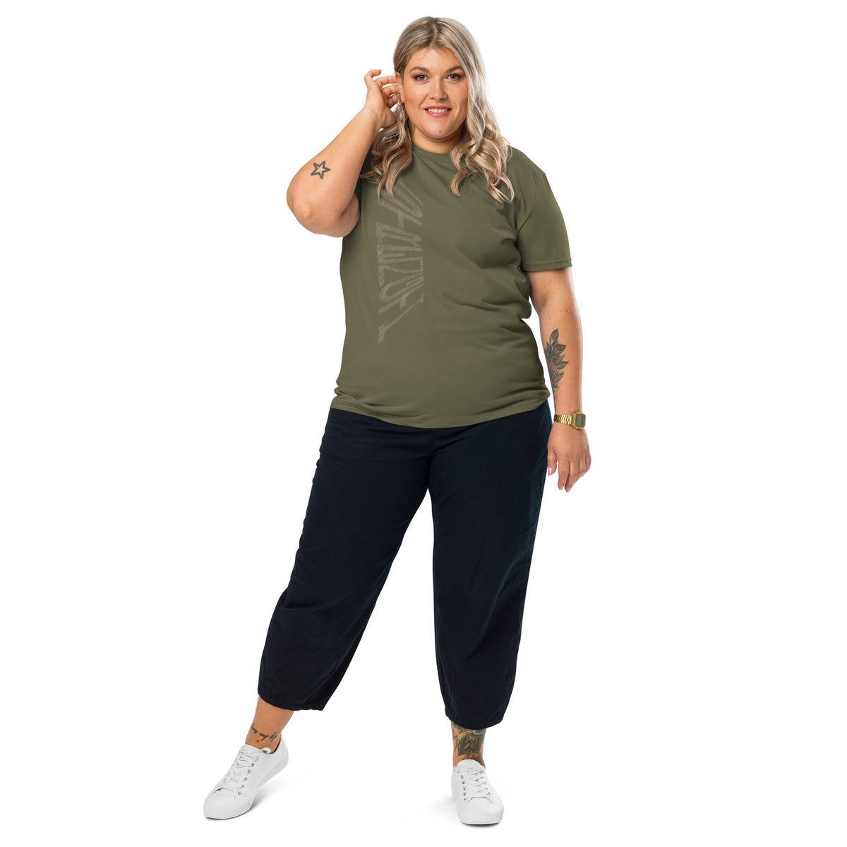 Woman wearing khaki green organic cotton t-shirt with hand-drawn 'Strength' text, black trousers and white sneakers | eKuumeArt.